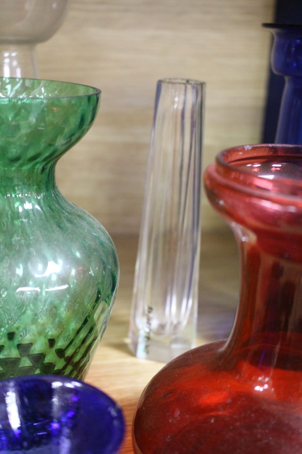 A collection of assorted coloured glassware including hyacinth vases, tallest 21cm